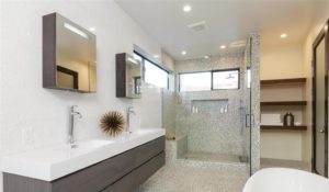 Modern Bathroom With Double Sinks, Walk-in Glass Shower, Open Shelves, And A Freestanding Tub.