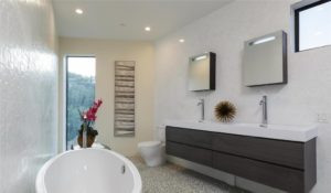 Modern Bathroom With A White Tub, Double Sink, Wall Mirrors, And Decorative Accents, Facing A Large Window.
